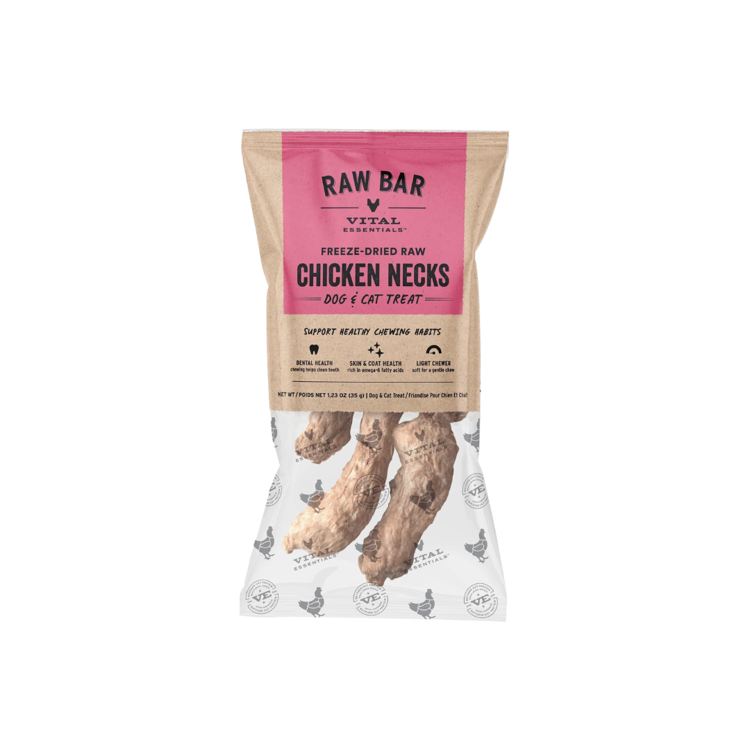 A bag of RAW BAR VITAL ESSENTIALs Freeze-Dried Raw Chicken Necks dog and cat treats, shown on a clean white background. The packaging features a kraft paper style with a prominent pink brand label and a clear lower section displaying the freeze-dried chicken neck treats inside.