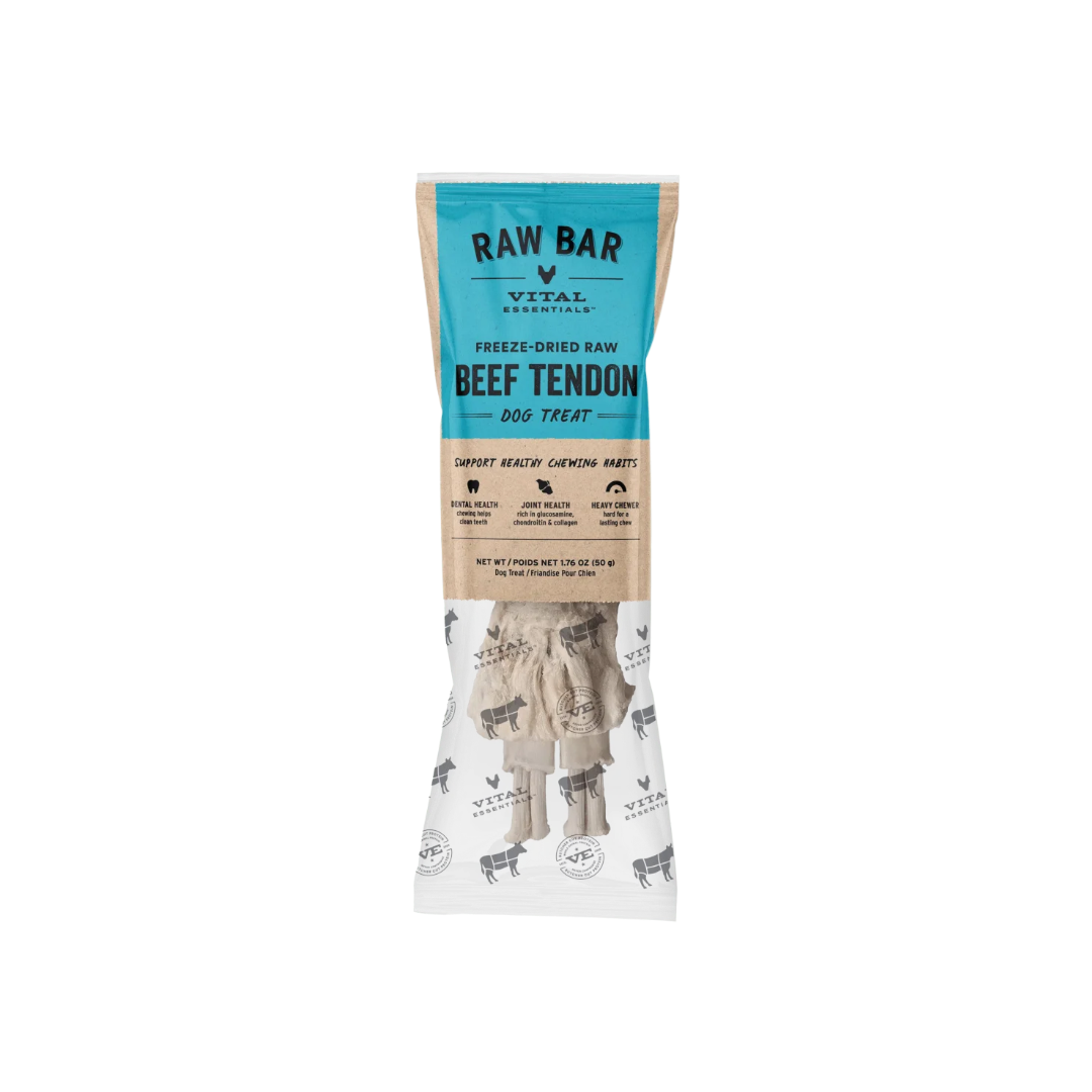 A package of RAW BAR Vital Essentials Freeze-Dried Raw Beef Tendon Dog Treats. The packaging features a teal blue top section with black text, a natural brown kraft paper middle section with product benefits, and a white bottom section showing the freeze-dried beef tendon treats inside.