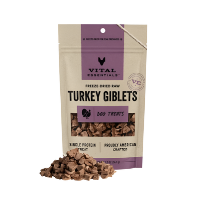 A package of Vital Essentials Freeze-Dried Raw Turkey Giblets Dog Treats with a transparent window showing the product. The package is purple and white with text and branding, and it is sealed with a resealable design.