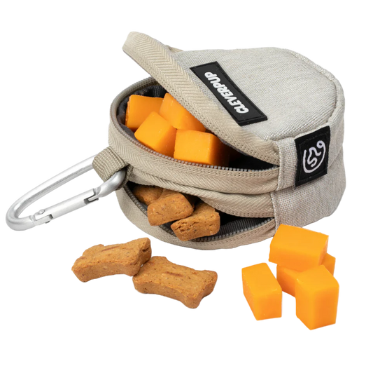 Pet treat pouch with dog biscuits and chew toys on a white background