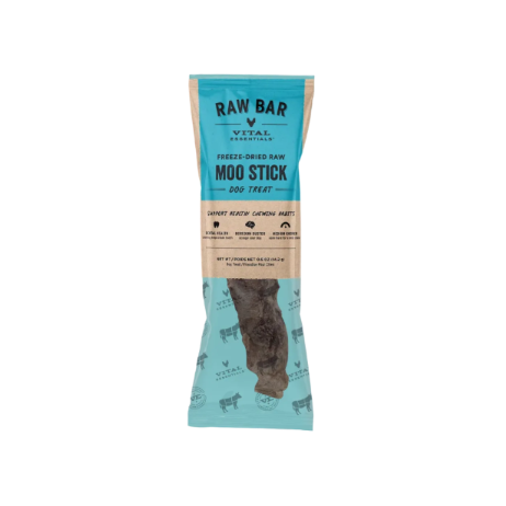 A packaged dog treat stick on a solid teal background. The package is a clear plastic bag with a light blue top label and a beige middle band, showing a dark brown freeze-dried raw Moo Stick dog treat inside.
